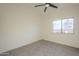 Neutral bedroom features carpet floors, a ceiling fan, and a view to the outside through a window at 11835 W Windsor Ave, Avondale, AZ 85392