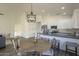 Bright kitchen with stainless appliances, breakfast bar, adjacent dining area, and a modern chandelier at 11835 W Windsor Ave, Avondale, AZ 85392