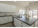 Bright kitchen features white cabinets, modern appliances, subway tile backsplash, and a gray countertop island at 11835 W Windsor Ave, Avondale, AZ 85392