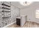 A modern bar area with a gray stone-look counter, black cabinets, decorative wallpaper, and stylish shelving at 12941 W Flower St, Avondale, AZ 85392