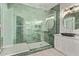 A modern green tiled shower and a sink with a granite countertop and new fixtures at 12941 W Flower St, Avondale, AZ 85392