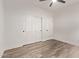 Bright bedroom features wood-look floors, a ceiling fan, and a closet with white sliding doors at 12941 W Flower St, Avondale, AZ 85392