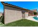 A backyard exterior view features turf, a stucco wall, a pool, and the home's architecture at 12941 W Flower St, Avondale, AZ 85392