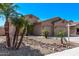 Charming single-story home featuring a two-car garage, desert landscaping with palms, and a well-maintained front yard at 12941 W Flower St, Avondale, AZ 85392