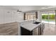 Bright kitchen with stainless steel appliances, an island, and sliding glass doors leading to the pool at 12941 W Flower St, Avondale, AZ 85392