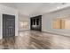 Spacious living room with wood floors, black built-in shelving, a front door and bright natural light at 12941 W Flower St, Avondale, AZ 85392