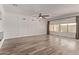 A bright, open living room with light wood-look floors, panel molding, and natural light from large windows at 12941 W Flower St, Avondale, AZ 85392