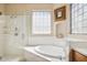 Bright bathroom with tub, shower, glass block window, and double sink vanity with storage at 13600 N Fountain Hills Blvd # 405, Fountain Hills, AZ 85268