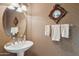 Elegant powder room with decorative mirror, sconces, pedestal sink, wallpaper, and towel bar at 13600 N Fountain Hills Blvd # 405, Fountain Hills, AZ 85268