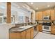 Bright kitchen featuring wood cabinets, stainless appliances, and a breakfast bar to adjacent living area at 13600 N Fountain Hills Blvd # 405, Fountain Hills, AZ 85268