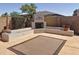 Cozy backyard features a fireplace with built-in seating and a decorative rug at 14437 W Lexington Ave, Goodyear, AZ 85395