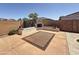 Backyard with outdoor fireplace, integrated seating, and a large rug at 14437 W Lexington Ave, Goodyear, AZ 85395