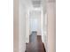 Bright hallway with wood-look tile flooring, white walls, and built-in storage at 14437 W Lexington Ave, Goodyear, AZ 85395