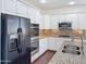 Modern kitchen features stainless steel appliances, granite countertops, and white cabinets at 14437 W Lexington Ave, Goodyear, AZ 85395