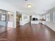 Open-concept living space with wood-look flooring, a kitchen, and white cabinetry at 14437 W Lexington Ave, Goodyear, AZ 85395