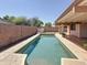 Backyard features a sparkling pool with sunning ledges, a built-in spa, and lush landscaping at 14437 W Lexington Ave, Goodyear, AZ 85395