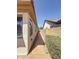 Side yard of the house showcasing a walkway, a small garden and privacy wall at 14437 W Lexington Ave, Goodyear, AZ 85395