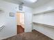 Walk-in closet with carpet flooring, shelving and doorway to ensuite bathroom at 14437 W Lexington Ave, Goodyear, AZ 85395