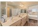 Well-lit bathroom with double sinks, spacious counter, and view into main bedroom at 14575 W Mountain View Blvd # 10313, Surprise, AZ 85374