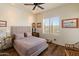 Comfortable bedroom featuring a large window with plantation shutters, wood floors, and neutral decor at 14575 W Mountain View Blvd # 10313, Surprise, AZ 85374