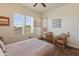Cozy bedroom with wood floors, a ceiling fan, a large window with plantation shutters, and comfortable furnishings at 14575 W Mountain View Blvd # 10313, Surprise, AZ 85374