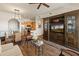 Living room showcasing open concept floorplan with kitchen views, wood floors, ceiling fan, and large windows with shutters at 14575 W Mountain View Blvd # 10313, Surprise, AZ 85374