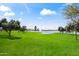 Scenic community green space featuring a lake, fountain, lush lawn, and mature trees under a bright blue sky at 14655 N Kings Way, Fountain Hills, AZ 85268
