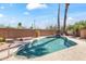 Refreshing pool with rock feature is surrounded by desert landscaping with mature palm trees at 14655 N Kings Way, Fountain Hills, AZ 85268