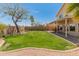 Lush green backyard featuring mature trees, desert landscaping, and a covered patio at 15055 S 40Th Pl, Phoenix, AZ 85044