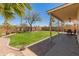Manicured backyard featuring grass, desert landscaping, block wall and covered patio at 15055 S 40Th Pl, Phoenix, AZ 85044