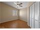 Neutral bedroom with hardwood floors, ceiling fan, a bright window, and a large closet at 15055 S 40Th Pl, Phoenix, AZ 85044