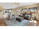 Open-concept living room with a ceiling fan, large windows, and adjacent kitchen at 15055 S 40Th Pl, Phoenix, AZ 85044