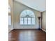 Bright living area featuring a large arched window, shutters, and hardwood floors, perfect for entertaining guests at 15055 S 40Th Pl, Phoenix, AZ 85044