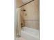 A cozy bathroom features a tiled tub and shower with a beige shower curtain and neutral tiles at 1506 E Tuckey Ln, Phoenix, AZ 85014