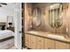 Luxurious bathroom featuring double sinks, modern lighting, stylish mirrors, and neutral tones at 1506 E Tuckey Ln, Phoenix, AZ 85014