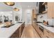 An open kitchen showcases an island, light wood cabinets, marble countertops, and stainless steel appliances at 1506 E Tuckey Ln, Phoenix, AZ 85014
