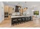 A modern kitchen features light wood cabinetry, a large island with seating, and elegant pendant lighting fixtures at 1506 E Tuckey Ln, Phoenix, AZ 85014