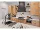 Modern kitchen with light wood cabinetry, a central island, and stainless steel appliances against white walls at 1506 E Tuckey Ln, Phoenix, AZ 85014
