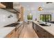 A stylish kitchen features an island, modern appliances, wood cabinets, and white marble countertops and backsplash at 1506 E Tuckey Ln, Phoenix, AZ 85014