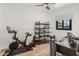 Bright office space with an exercise bike, desk, and modern shelving offering a comfortable workspace at 1506 E Tuckey Ln, Phoenix, AZ 85014