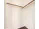 Walk-in closet features a wooden hanging rod and white walls at 16150 N 86Th Ave, Peoria, AZ 85382