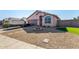 Inviting single-story home with a well-manicured lawn, desert landscaping, and a fire pit at 16150 N 86Th Ave, Peoria, AZ 85382