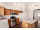 Eat-in kitchen with stainless steel appliances, breakfast bar, track lighting, and access to the rest of the house at 16150 N 86Th Ave, Peoria, AZ 85382