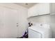 Laundry room featuring white cabinets and a washing machine at 16150 N 86Th Ave, Peoria, AZ 85382
