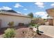 Charming backyard features desert landscaping with rock accents, synthetic grass, and patio space at 16160 W Starlight Dr, Surprise, AZ 85374