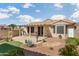 Well-maintained backyard featuring a covered patio, desert landscaping, and artificial turf area at 16160 W Starlight Dr, Surprise, AZ 85374