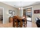 Cozy dining area with wood table and chairs, a stylish mirror, and sliding door access to the backyard at 16160 W Starlight Dr, Surprise, AZ 85374