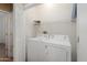 This laundry room features a white washer and dryer, wire shelf, and white walls for easy cleaning and maintenance at 16160 W Starlight Dr, Surprise, AZ 85374