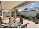 The covered patio features a table and chairs, a grassy area, and desert landscaping at 16160 W Starlight Dr, Surprise, AZ 85374