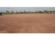 Well-maintained baseball field with groomed dirt infield, neatly lined baselines, and distant views of mature trees at 16526 W Calle Lejos --, Surprise, AZ 85387